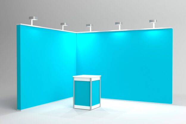Empty blue exhibition booth with counter and spotlights. Autorskie projekty stoisk targowych – dlaczego personalizacja ma znaczenie?